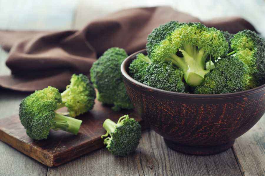 Sebuah piring penuh brokoli kukus yang berwarna hijau cerah, siap untuk dinikmati, menonjolkan sayuran yang kaya akan vitamin dan mineral penting untuk kesehatan jantung dan tulang